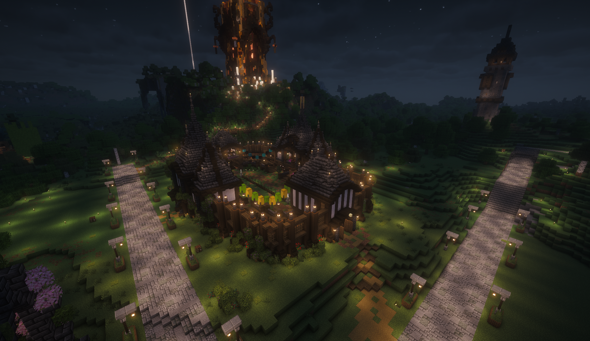 Lantern-lit pagoda compound at night with a towering tree build beyond