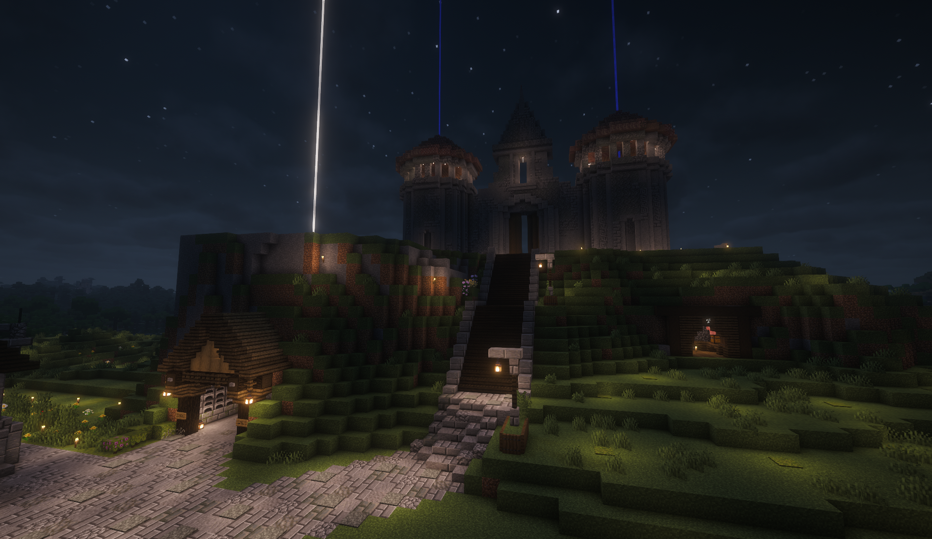 Castle on a grassy hill at night with a staircase leading to the gate