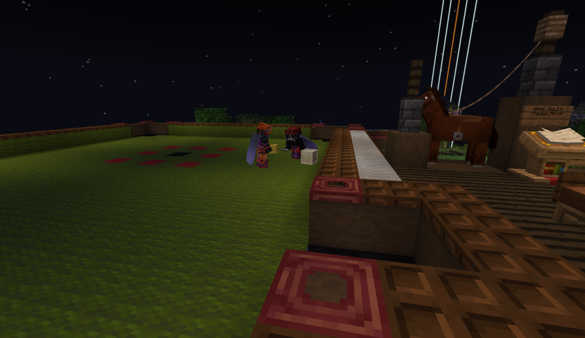 Members at a night game beside a wooden horse statue
