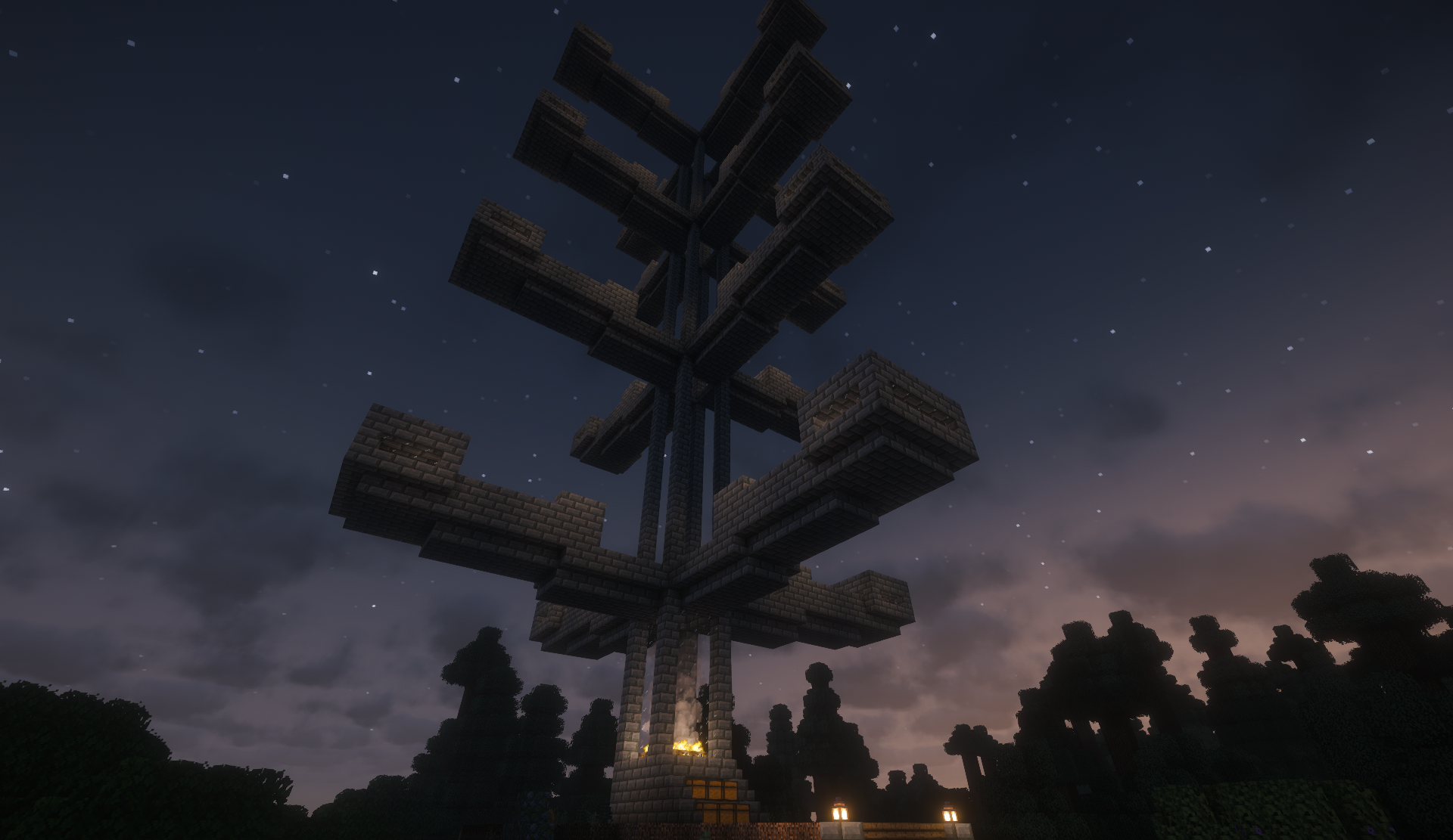 Tall stone brick tree-shaped tower at night, with a campfire glowing at its base